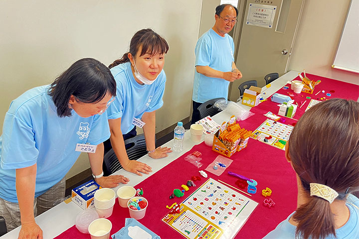 カラー粘土を混ぜ合わせて別の色をつくるレシピを準備する社員